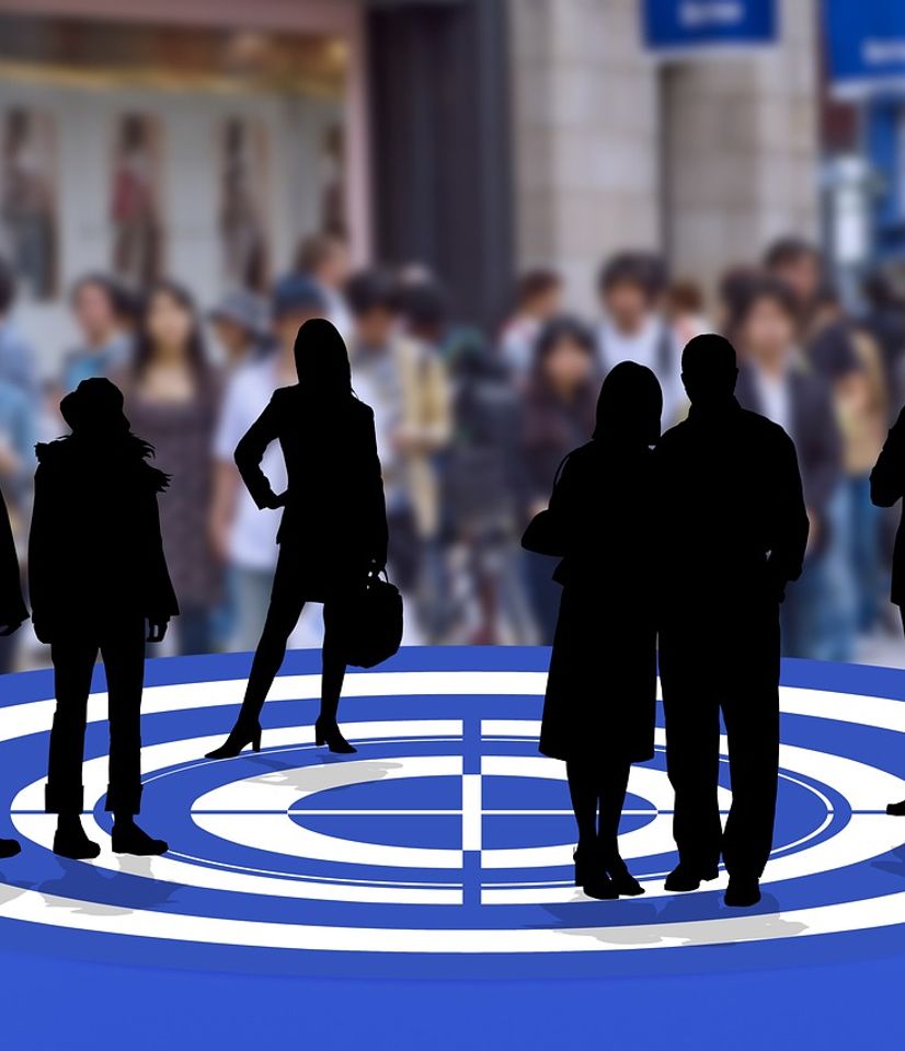 A group of shadow-y people pose on top of a bullseye